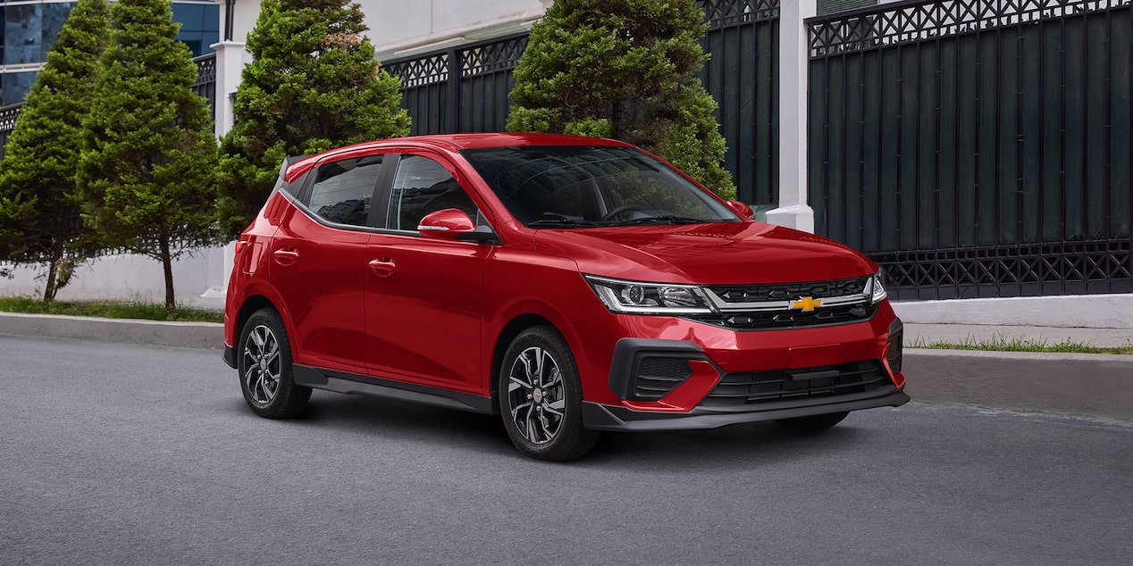 Vista delantera lateral de Chevrolet Aveo HB 2025, con faros de halógeno proyector y LED diurnas con direccional integrada