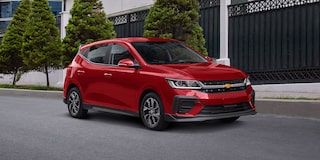 Vista delantera lateral de Chevrolet Aveo HB 2025, con faros de halógeno proyector y LED diurnas con direccional integrada